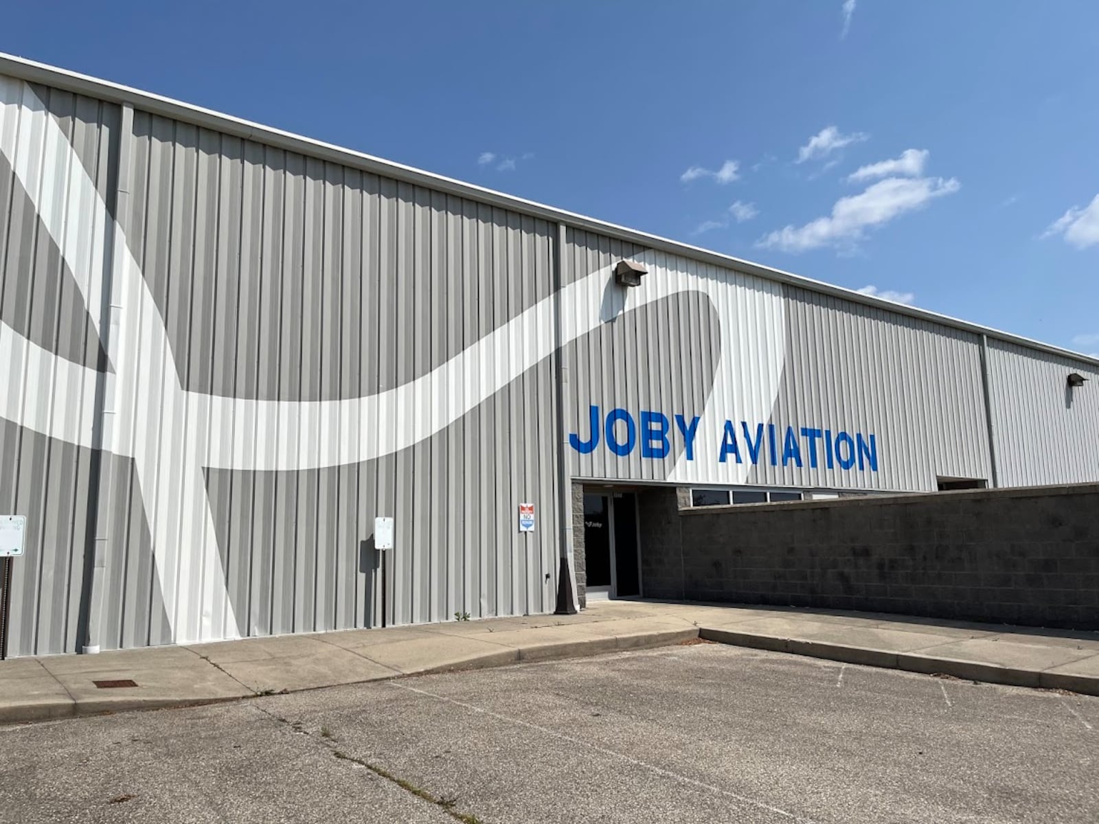 The outside of the former U.S. Postal Service facility near Dayton International Airport sported a new paint job on Tuesday, June 10, 2025 as Joby Aviation prepares the building for occupation. THOMAS GNAU/STAFF