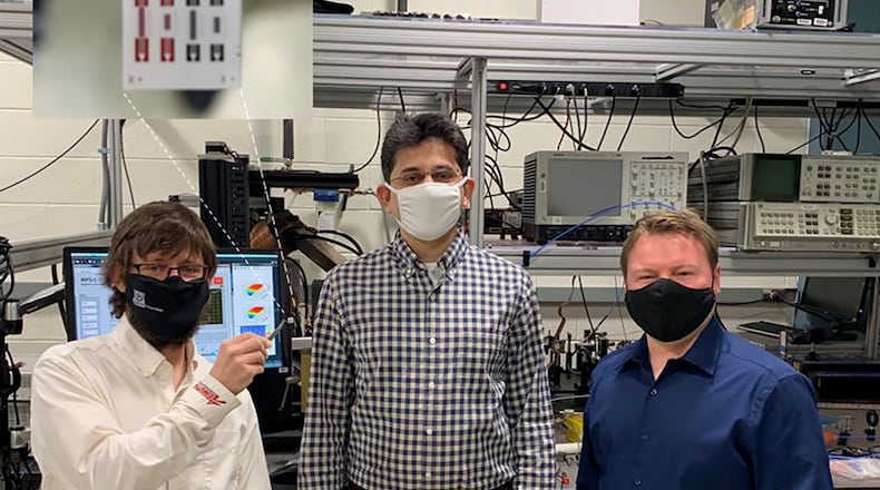 From the left to right: Air Force Research Laboratory scientists Drs. Derek A. Bas, Piyush J. Shah and Michael R. Page. In the tweezers, Bas is holding a chip that contains an array of four isolators. A state-of the-art commercial RF isolator has a much greater size and weight than the AFRL device. U.S. AIR FORCE PHOTO/DR. MICHAEL WOLF
