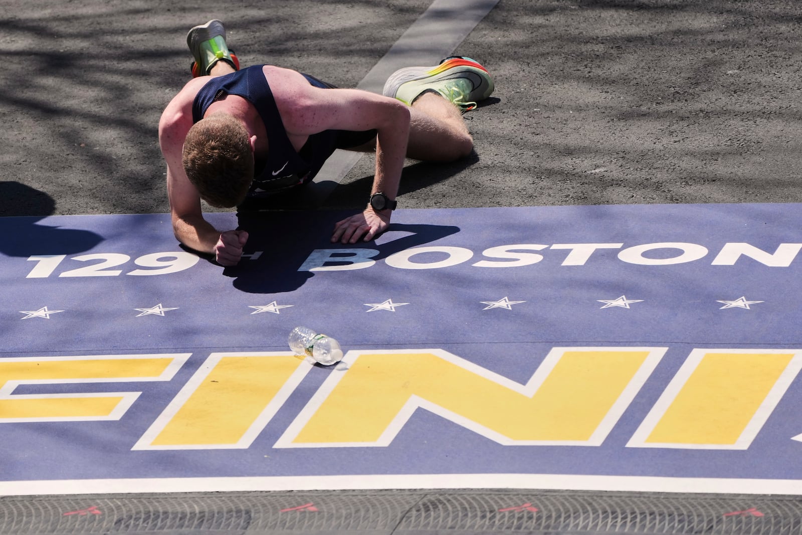 Runner Matthew Nawn crawls to cross the finish line during the Boston Marathon, Tuesday, April 22, 2025, in Boston. (AP Photo/Charles Krupa)