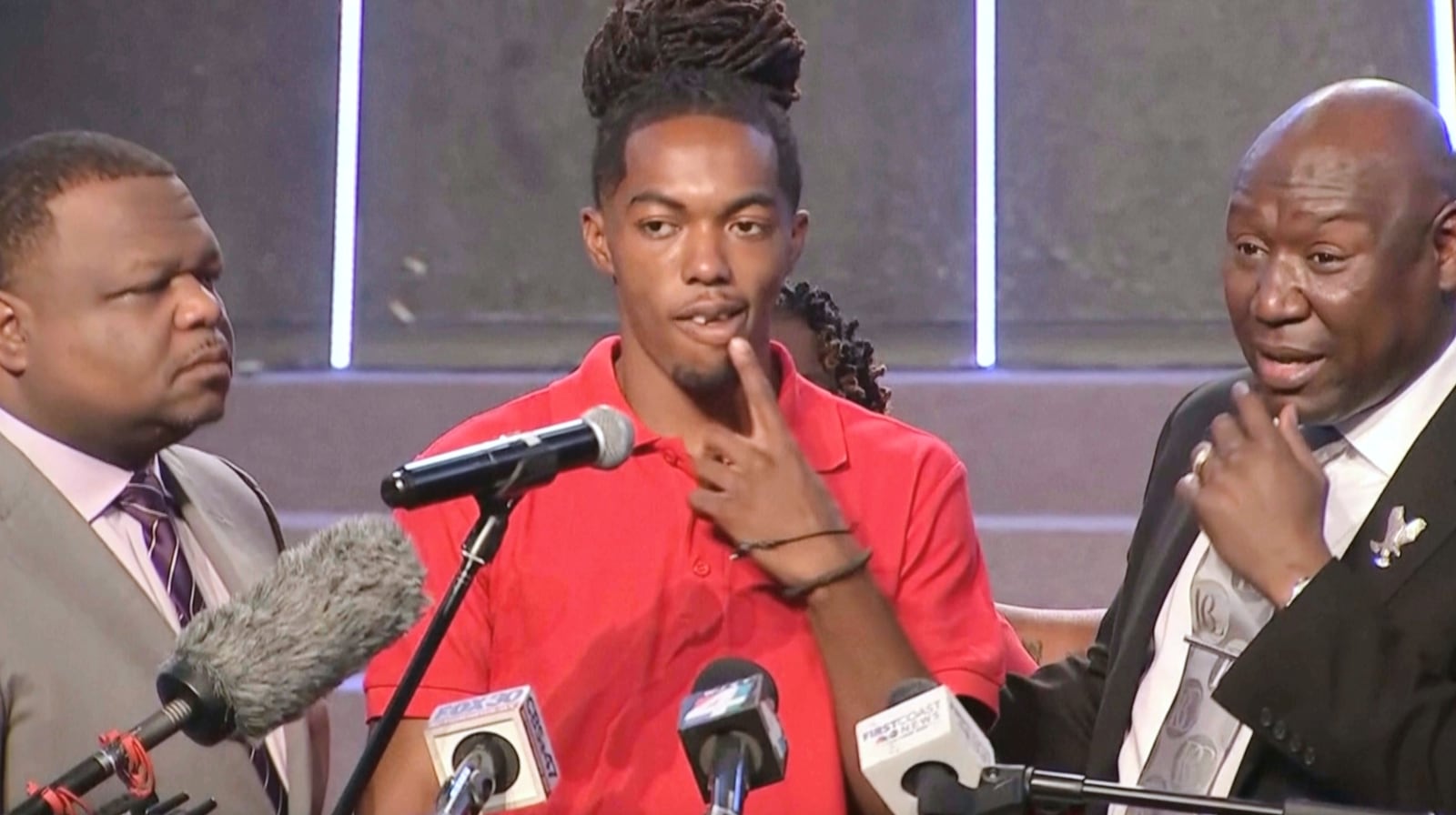 This image taken from video provided by WJAX shows William McNeil Jr., center, listening as his attorney Ben Crump, right, speaks during a news conference in Jacksonville, Fla., Wednesday, July 23, 2025. (WJAX via AP)