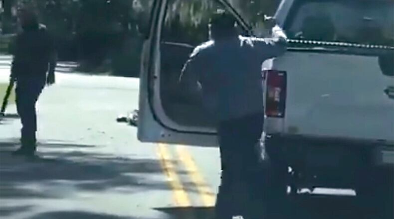 This image from video posted on Twitter Tuesday, May 5, 2020, purports to show Ahmaud Arbery lying on the road after being shot as Travis McMichael, left, holding a shotgun, and his father, Gregory McMichael, holding a handgun, approach him in a neighborhood outside Brunswick, Ga., on Feb. 23, 2020. The AP has not been able to verify the source of the video. (Twitter via AP) (AP)