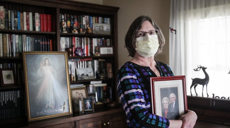 Mary Sutton holds a picture of her mother, Alvera Gudorf, who lost her life to COVID-19 at Koester Pavilion nursing home in Tipp City. “She was tough as nails,” Sutton said. “She was going to go out kicking and screaming and then COVID-19 came along.” JIM NOELKER/STAFF