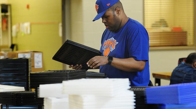 Jorge sorts through plastic trays for shipping, one of his tasks to earn a paycheck through the federal 14 c program. MARSHALL GORBY\STAFF