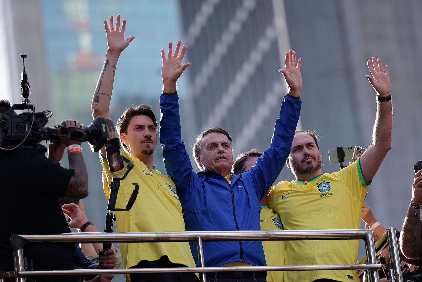 Former President Jair Bolsonaro, center, gestures to the crowd with his sons Jair Renan Bolsonaro, left, and Carlos Bolsonaro, during a protest against his Supreme Court trial, in which he is accused of involvement in a 2022 coup attempt, in Sao Paulo, Sunday, June, 29, 2025. (AP Photo/Ettore Chiereguini)