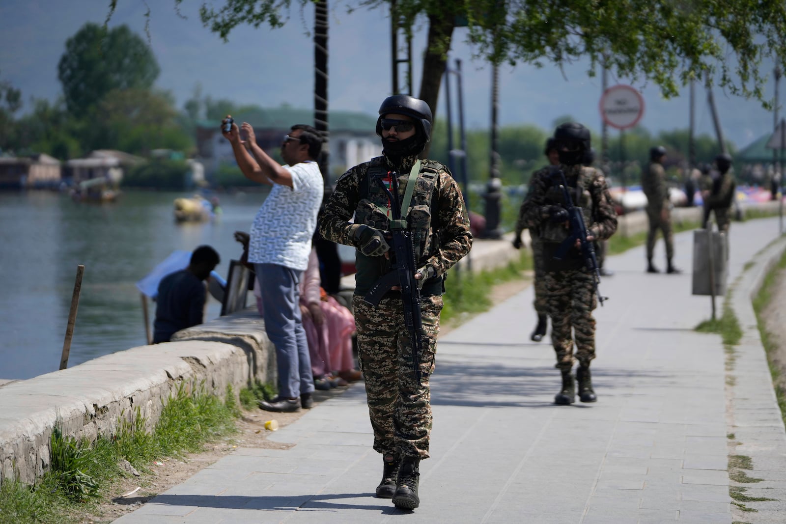 Indian soldiers guard as a tourist take picture with his cell phone on the banks of Dal Lake in Srinagar, Indian controlled Kashmir, Thursday, April 24, 2025. (AP Photo/Mukhtar Khan)