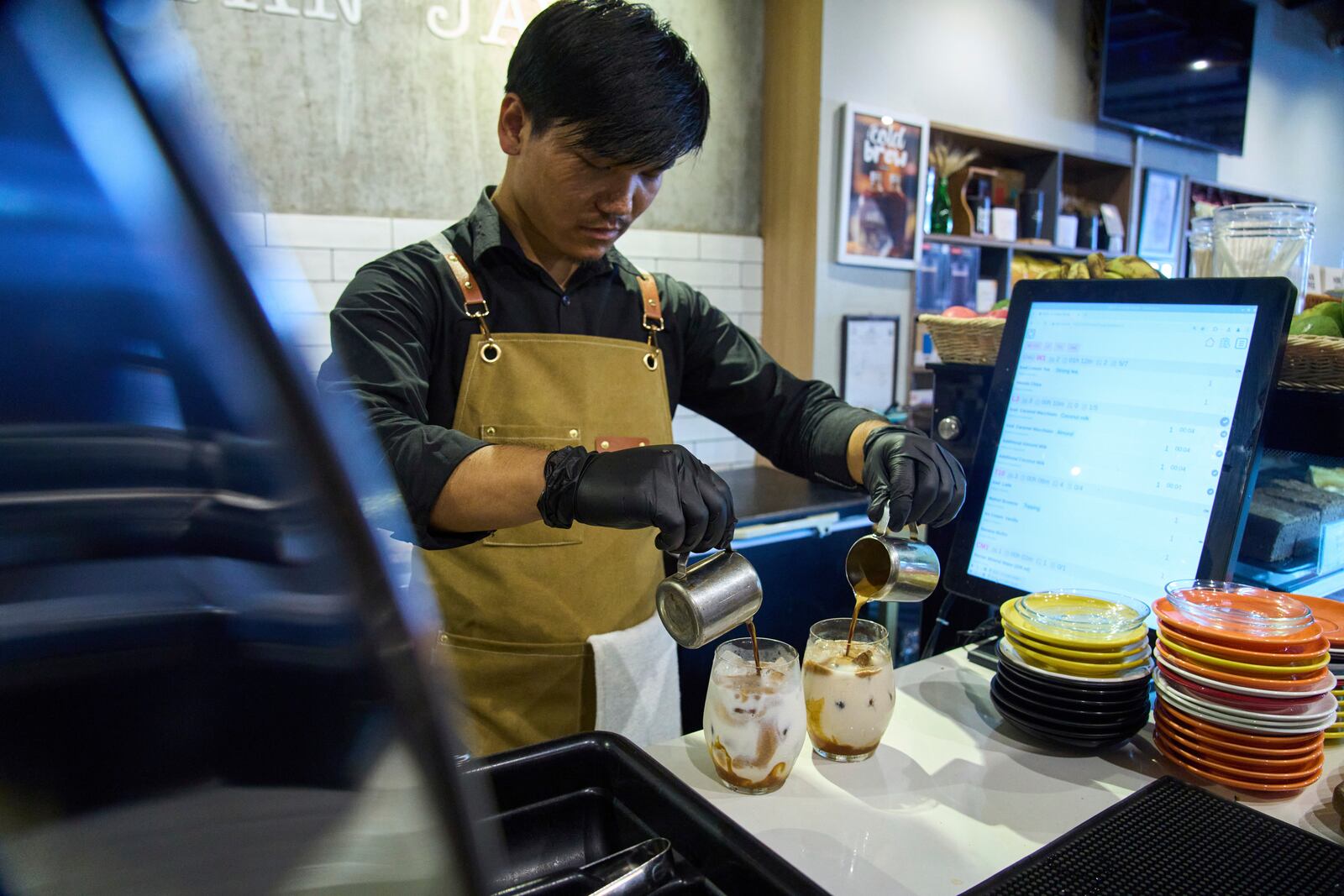 An employee prepares a coffee for a customer at Himalayan Java cafe at Boudhanath Stupa in Kathmandu, Nepal, Tuesday, June 10, 2025. (AP Photo/Niranjan Shrestha)
