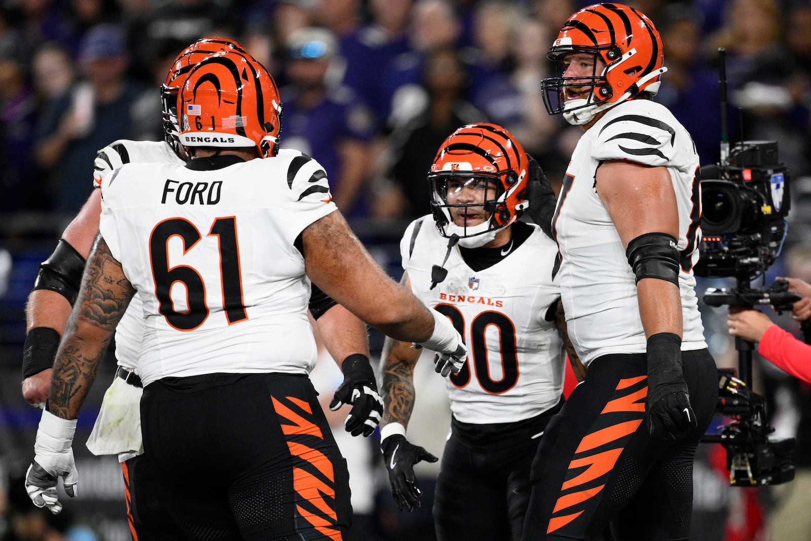 Cincinnati Bengals running back Chase Brown, second from right, celebrates scoring a touchdown with teammates, including Cincinnati Bengals guard Cody Ford (61), during the first half of an NFL football game against the Baltimore Ravens, Thursday, Nov. 7, 2024, in Baltimore. (AP Photo/Nick Wass)