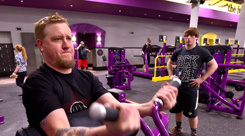 Ryan Patrick does curls as his son Macaden Patrick, 15 watches at the Planet Fitness in the Towne Mall Galleria in Middletown in 2016. Teens will be able to workout for free this summer. NICK GRAHAM/STAFF