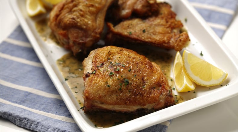 Chicken thighs start out on the stovetop, then are transferred right in the skillet to a hot oven. A quick pan sauce finishes the dish. (Mark Graham/food styling) (E. Jason Wambsgans/Chicago Tribune/TNS)