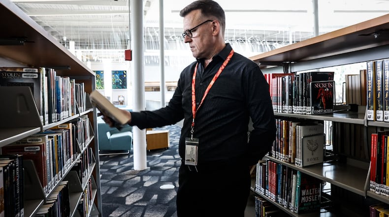Dayton Metro Library executive director Jefferey Trzeciak looks through the stacks Wednesday June 21, 2023. The Dayton Metro Library has been declared a book sanctuary which means the library collects and protects endangered books. JIM NOELKER/STAFF