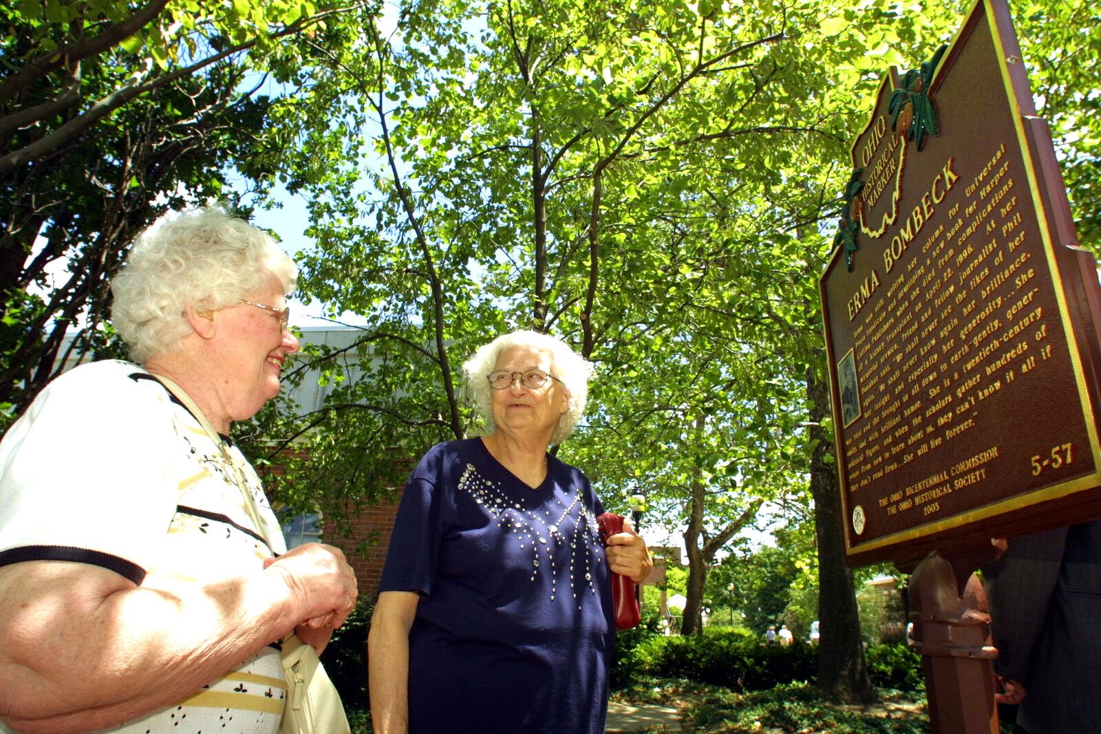Mary (L) and Betty Fiste take a look at the newly unveiled  Erma Bombeck historical marker on the walkway across from St. Mary's Hall on the University of Dayton campus. The two Miami Valley women are relatives (their husbands are first cousins to Erma) and attended the dedication ceremony. Erma Bombeck is a 1949 alumna of UD.