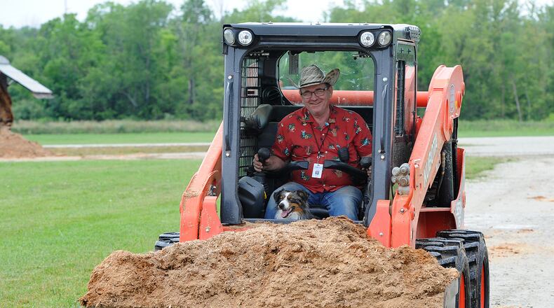 Montgomery County Fair broad member Chris Craft, and his faithful companion Tucker, deliver sawdust to cover muddy areas in front of vendors at the fairgrounds Tuesday, July 13, 2021. MARSHALL GORBY\STAFF