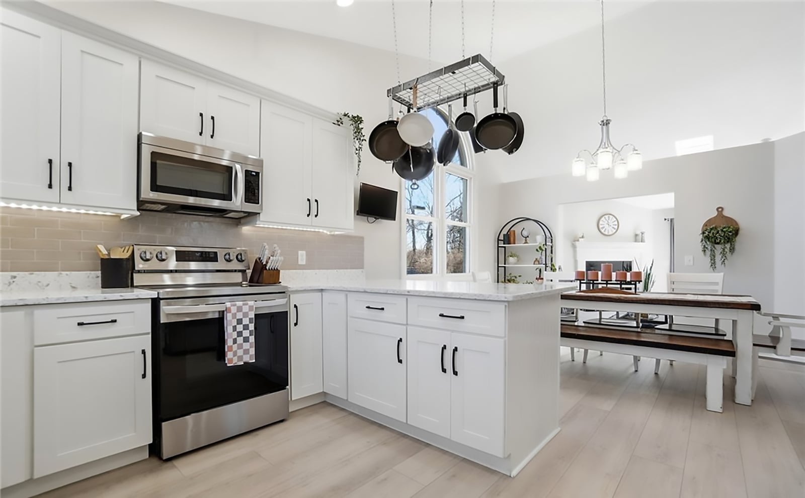 The newly updated kitchen has plank flooring, white cabinets, granite countertops and a tile backsplash. The breakfast area has a decorative chandelier and vaulted ceiling. CONTRIBUTED