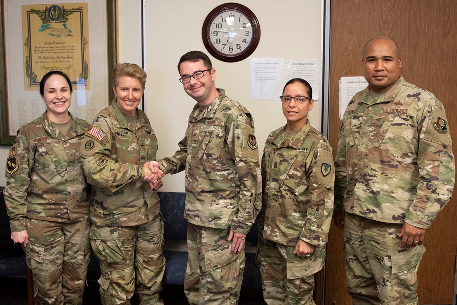 Army Brig. Gen. Christine Beeler (second from left), commander of Mission and Installation Contracting Command, presents a coin to Staff Sgt. Stephan Giorgio, a contracting officer with the Air Force Life Cycle Management Center, for his work during the joint force contracting exercise June 24 at Wright-Patterson Air Force Base. U.S. AIR FORCE PHOTO/WESLEY FARNSWORTH