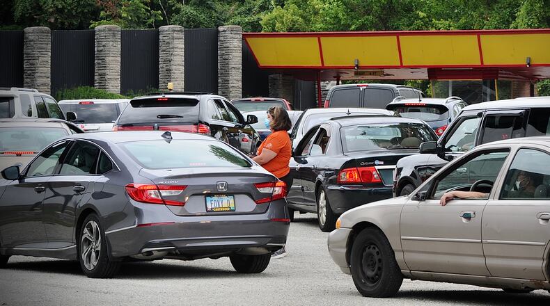 Vehicles line up to enter the Dixie drive-in for the Foodbank mass food distribution Aug. 16. Foodbanks are among those advocating for some of the remaining Ohio ARPA rescue funds. MARSHALL GORBY\STAFF