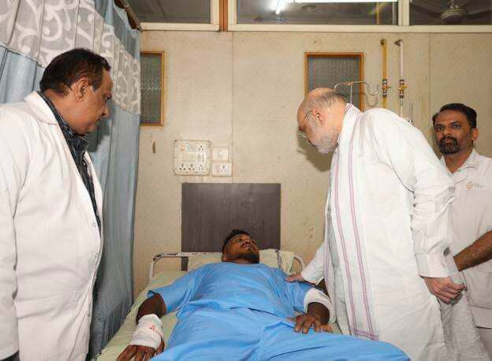 This handout photo issued by the Indian Ministry of Home Affairs shows Home Affairs Minister Amit Shah meeting British plane crash survivor Vishwash Kumar Ramesh, 40, at a hospital in Ahmedabad, after Air India confirmed Mr Ramesh was the sole survivor of the 242 people on board the London-bound Boeing 787 Dreamliner when it crashed into a medical college shortly after take-off from Ahmedabad airport. (Ministry of Home Affairs India via AP)