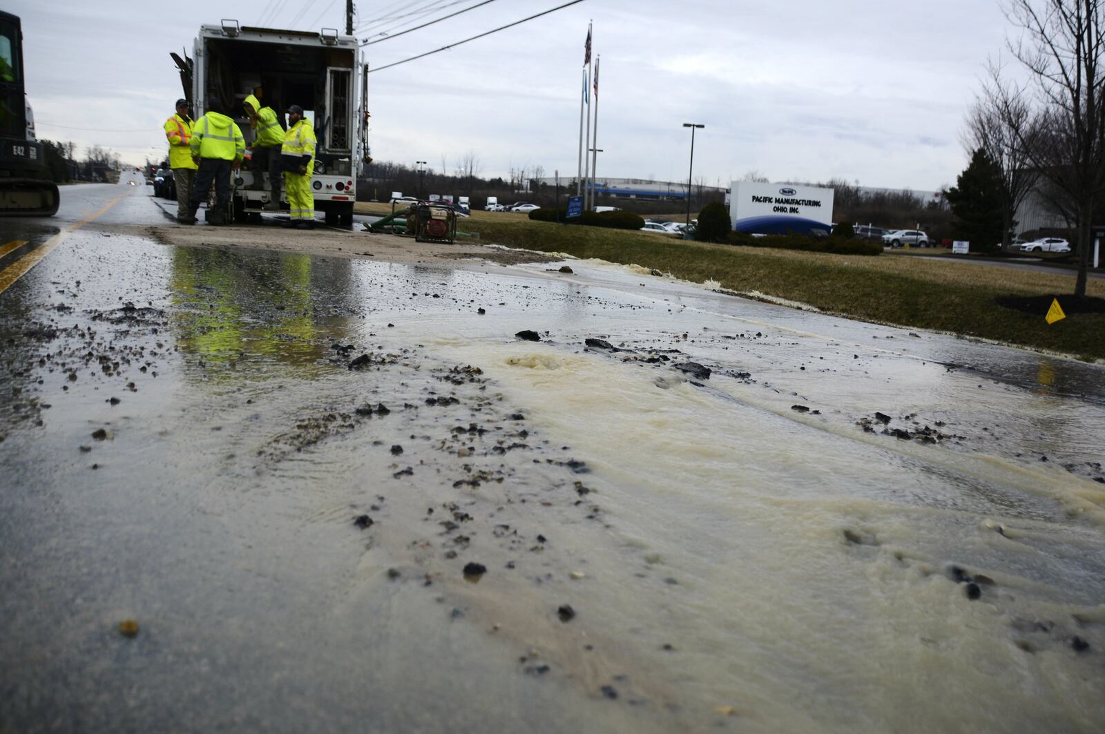A large water main break on Wednesday in front of Pacific Manufacturing Ohio on Seward Road in Fairfield ended up buckling part of the road and force it to close for much of the day. MICHAEL D. PITMAN/STAFF