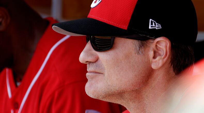 Cincinnati Reds manager David Bell watches from the dugout during the first inning of a spring training baseball game against the Milwaukee Brewers, Sunday, March 3, 2019, in Phoenix. (AP Photo/Charlie Riedel)