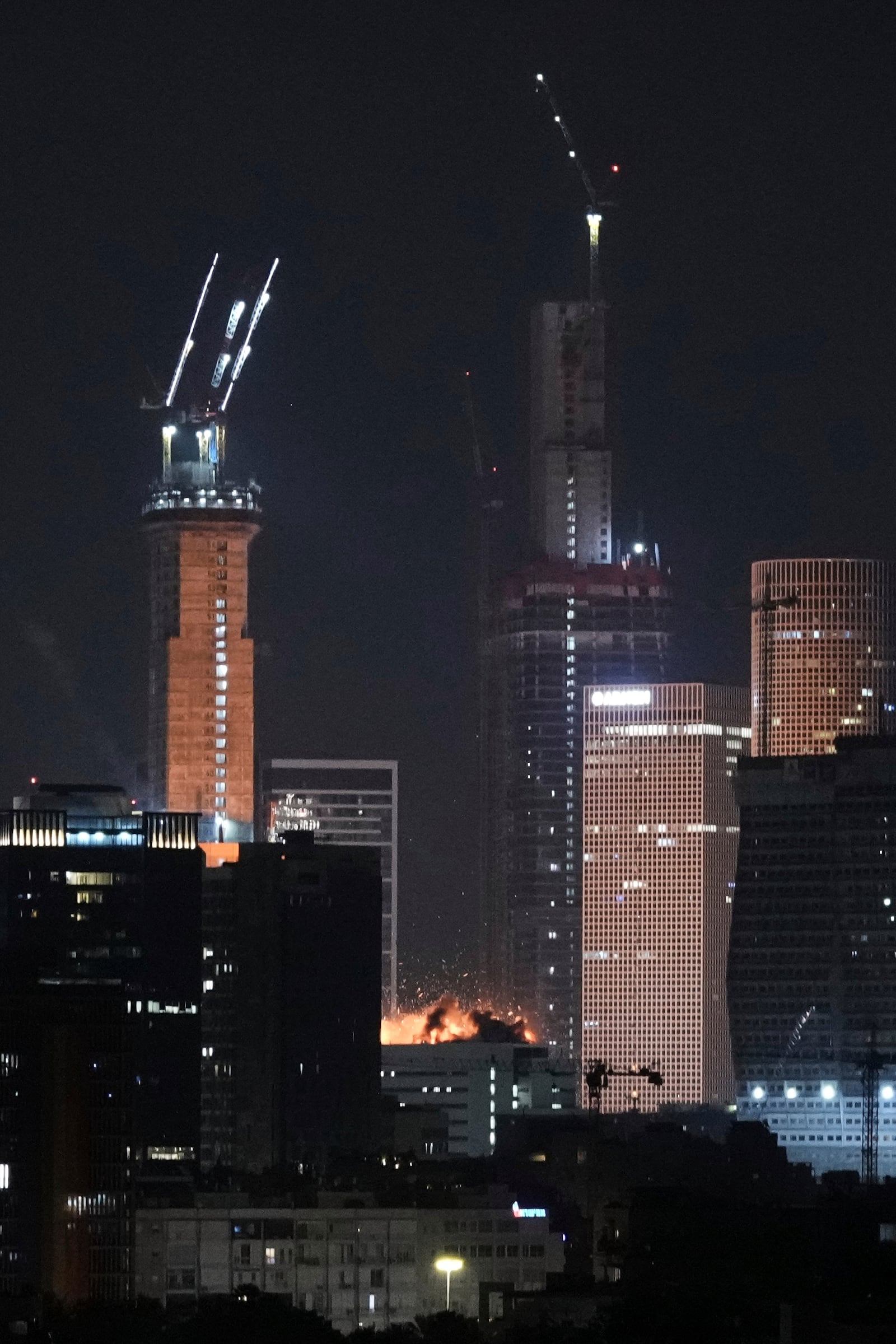 A projectile hits a building in Tel Aviv, Israel, early Saturday, June 14, 2025. (AP Photo/Leo Correa)