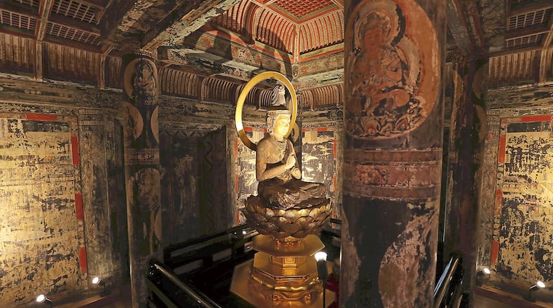 The interior of the first level of the three-story pagoda at Saimyoji temple in Kora, Japan. A seated Dainichi Nyorai Buddha statue in the center is surrounded by richly colored murals depicting the world of Buddha. Yomiuri/Japan News photo.