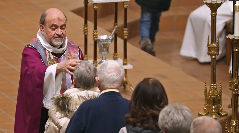 Parishioners at St. Raphaels Catholic Church receive ashes on their foreheads during Ash Wednesday services. Ash Wednesday marks the first day of Lent. BILL LACKEY/STAFF