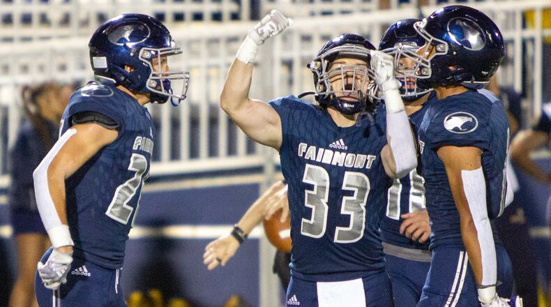 Fairmont's Stevie Doty (left), Max Conlon (33) and Kamron Payne celebrate Doty's fourth-quarter interception in Friday night's 10-7 victory over Springfield at Roush Stadium. Jeff Gilbert/CONTRIBUTED