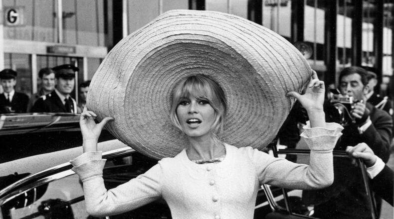 FILE - French actress Brigitte Bardot poses with a huge sombrero she brought back from Mexico, as she arrives at Orly Airport in Paris, France, on May 27, 1965. (AP Photo/File)
