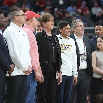 Dayton athletic direcotr Neil Sullivan, third from left, poses for a photo with UD President Eric Spina, to Sullivan's right, and A-10 Commissioner Bernadette V. McGlade, center, at the A-10 tournament on Sunday, March 15, 2026, at PPG Paints Arena in Pittsburgh. David Jablonski/Staff