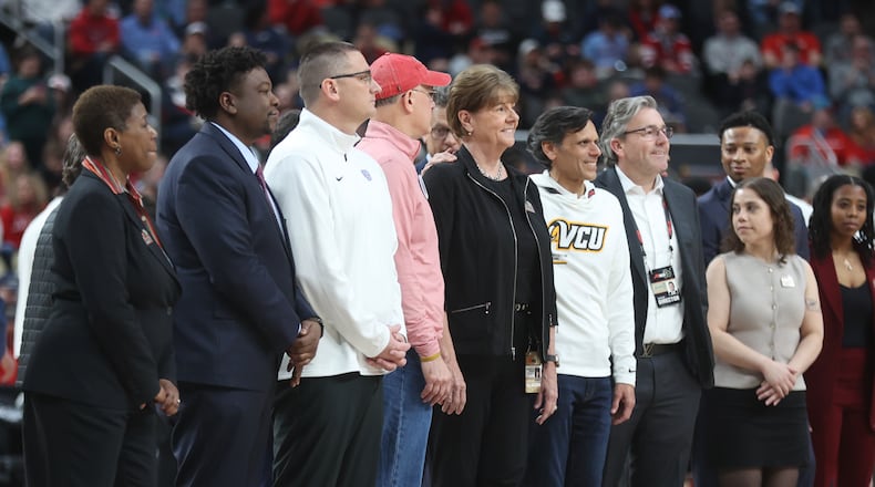 Dayton athletic direcotr Neil Sullivan, third from left, poses for a photo with UD President Eric Spina, to Sullivan's right, and A-10 Commissioner Bernadette V. McGlade, center, at the A-10 tournament on Sunday, March 15, 2026, at PPG Paints Arena in Pittsburgh. David Jablonski/Staff