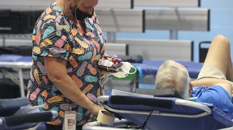 People give blood at blood drive Tuesday at the First Christian Church on Middle Urbana Road. BILL LACKEY/STAFF