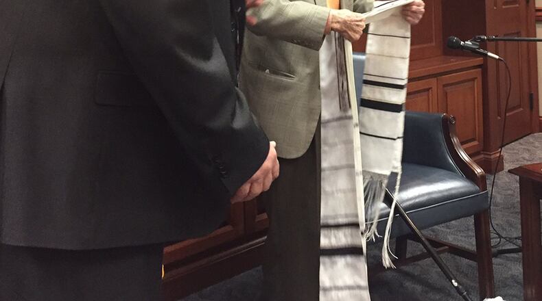 Samuel Heider, a Holocaust survivor who spoke to Wright-Patterson Air Force Base personnel April 30, prepares to don his prayer shawl as Scott Olgeaty, Services Management Division chief, Business Enterprise Systems Directorate, Air Force Life Cycle Management Center looks on. (Skywrighter photo/Amy Rollins)