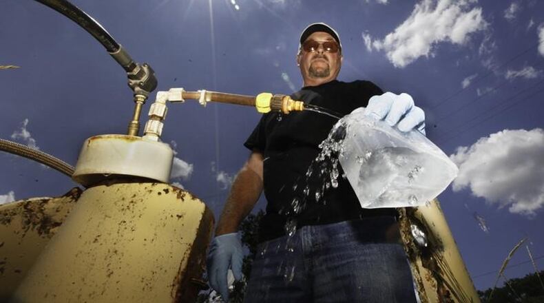 In this 2017 photo, Dan Day, a water lab technician with the City of Dayton, takes a sample from one of 200 monitoring wells used to check on the quality of water in the Great Miami Buried Valley Aquifer and test for any contaminants on a regular basis. CHRIS STEWART / STAFF