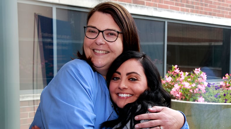 Amanda Donnelly, left, hugs Alaina Tuttle outside the Birthing Center at Springfield Regional Medical Center Thursday, August 8, 2024. Amanda was Alaina's nurse when she was a small girl battling cancer at Dayton Children's Hospital and now 20 years later Alaina is a nursing and they both work together at the Springfield hospital. BILL LACKEY/STAFF
