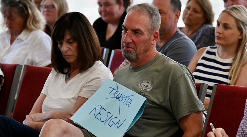 For the second consecutive meeting, Ross Twp. residents on Aug. 7, 2025, showed up calling for Trustee David Young to resign following racist comments he made on a Facebook post following the Cincinnati brawl in late July. Trustees called a special meeting on July 31, 2025, to address the comments and the fallout. Young apologized but refused to resign after being asked by residents and fellow trustees. He's seeking another term as trustee in this fall's election. Pictured is township resident Douglas Fraits holding a sign calling for Young to resign. MICHAEL PITMAN/STAFF