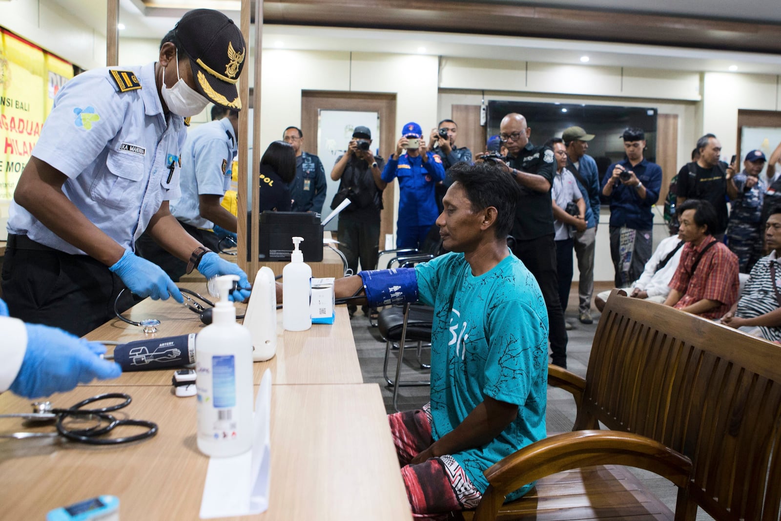 A paramedic gives health examination to a survivor rescued after a ferry sank, in Gilimanuk on Bali island, Indonesia, Thursday, July 3, 2025. (AP Photo/Firdia Lisnawati)