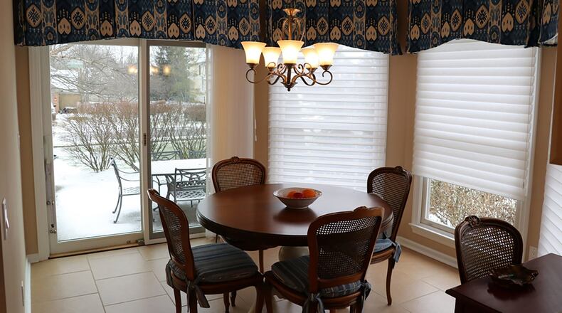 Under an octagonal tray ceiling, the breakfast room’s semi-circle of three large windows joins sliding glass doors that access the patio.