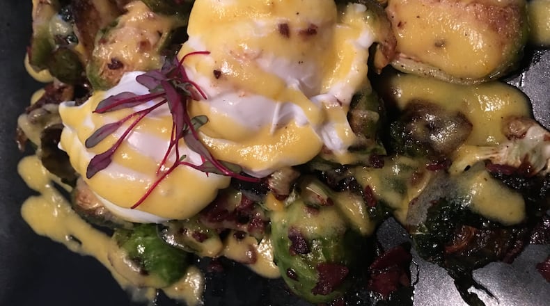Roasted brussel sprouts ($9), topped with crispy pieces of bacon, drizzles of Hollandaise sauce and poached eggs. Contributed photo by Alexis Larsen