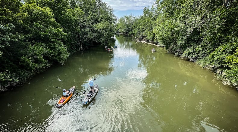 A couple of kayakers float down Twin Creek for overnight camping and fishing near West Alexander JIM NOELKER/STAFF.