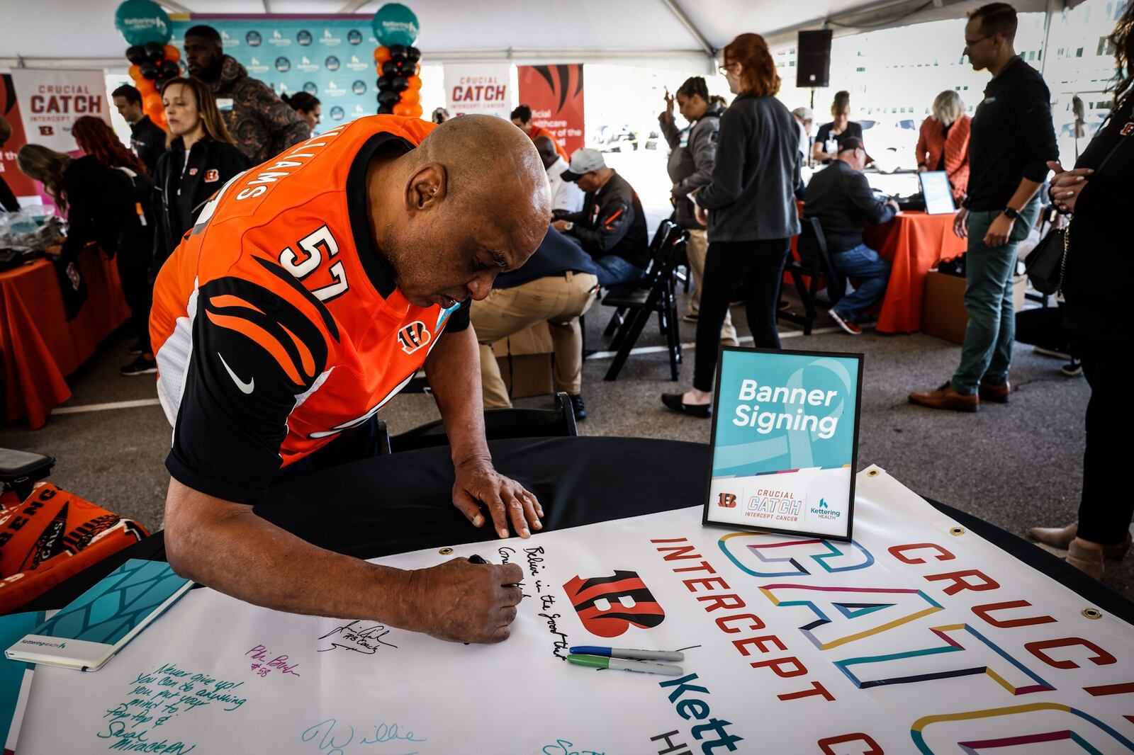 Bengals legend Reggie Williams signs a banner at the Kettering Health Cancer Center on Thursday September 29, 2022. The Bengal legends were at the hospital to deliver care packages, sign banners and visit cancer patients. JIM NOELKER/STAFF