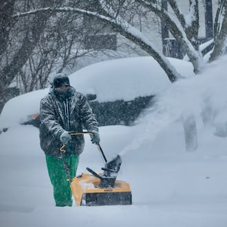 A woman is up to her knees in snow clearing her windows at the McDonald’s near Wright State University early Sunday morning, Jan. 25, 2026. BUCK CREEK PHOTOGRAPHY/CONTRIBUTED