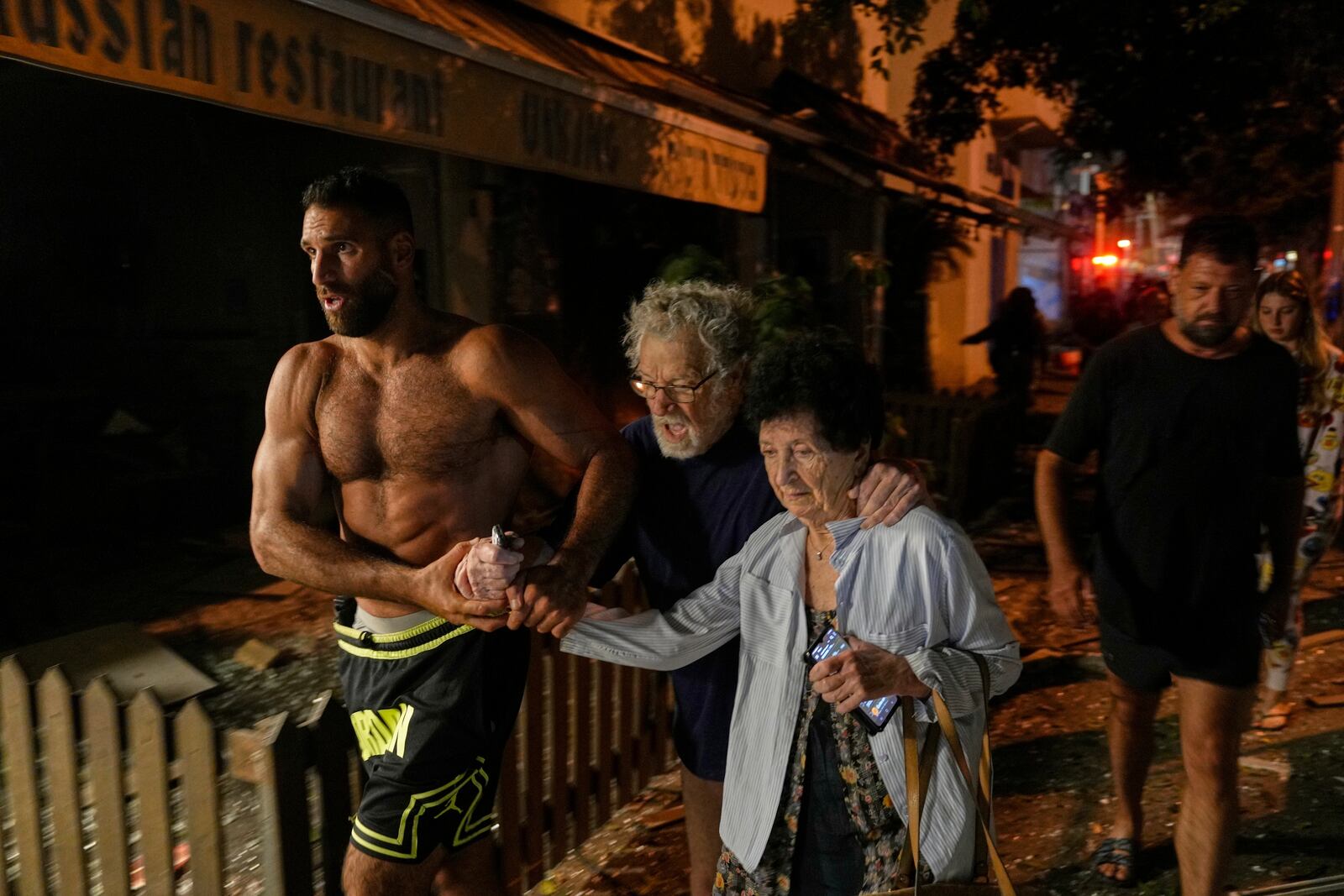 People evacuate after a missile launched from Iran struck Tel Aviv, Israel, Monday June 16, 2025. (AP Photo/Baz Ratner)