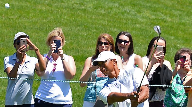 Fans take photos and watch as golfer Tiger Woods chips onto the 2nd green in preparation for the Wells Fargo Championship at Quail Hollow Club in Charlotte, N.C., on May 1, 2018. (Jeff Siner/Charlotte Observer/TNS)