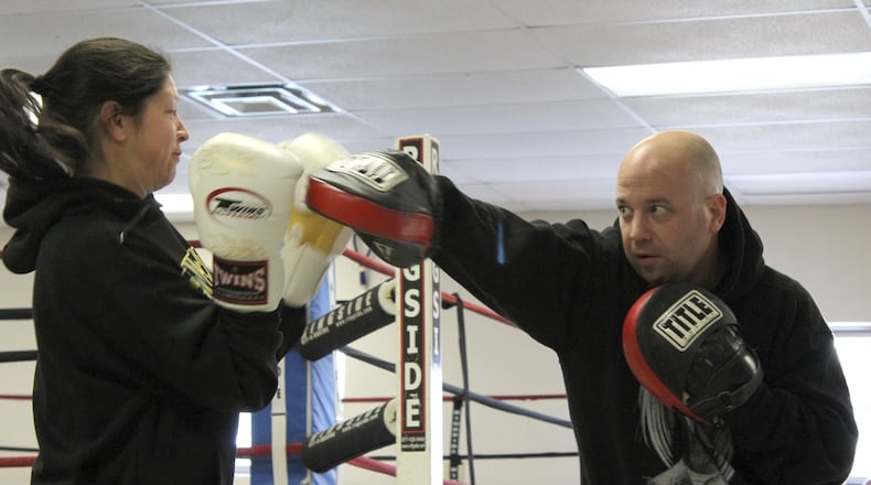 Students at Brown Institute of Martial Arts practices striking techniques using focus pads to improve their punching accuracy and hand-eye coordination. (ANDREW SMITH/STAFF)