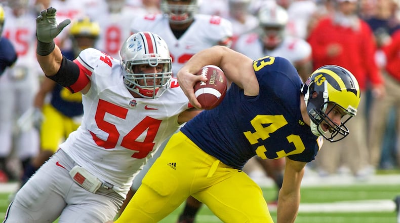 Ohio State Buckeyes defensive tackle John Simon (54) chases Michigan Wolverines punter Will Hagerup (43) after his fumble of the snap in the third quarter of the game between Ohio State and Michigan at Michigan Stadium, Ann Arbor, Michigan. Michigan defeated Ohio State 40-34.