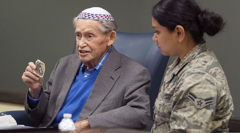Sam Heider, a Holocaust survivor, holds up a picture of his sister, who was killed by the Nazis during World War II. Heider discussed his experiences during the war at a presentation Oct. 19 at the Air Force Life Cycle Management Center headquarters on Wright-Patterson Air Force Base. Heider managed to keep the photo with him and hidden throughout his imprisonment in German concentration camps. It is the only photo he has of any of his family members who all died in the Holocaust. (U.S. Air Force photo/R.J. Oriez)