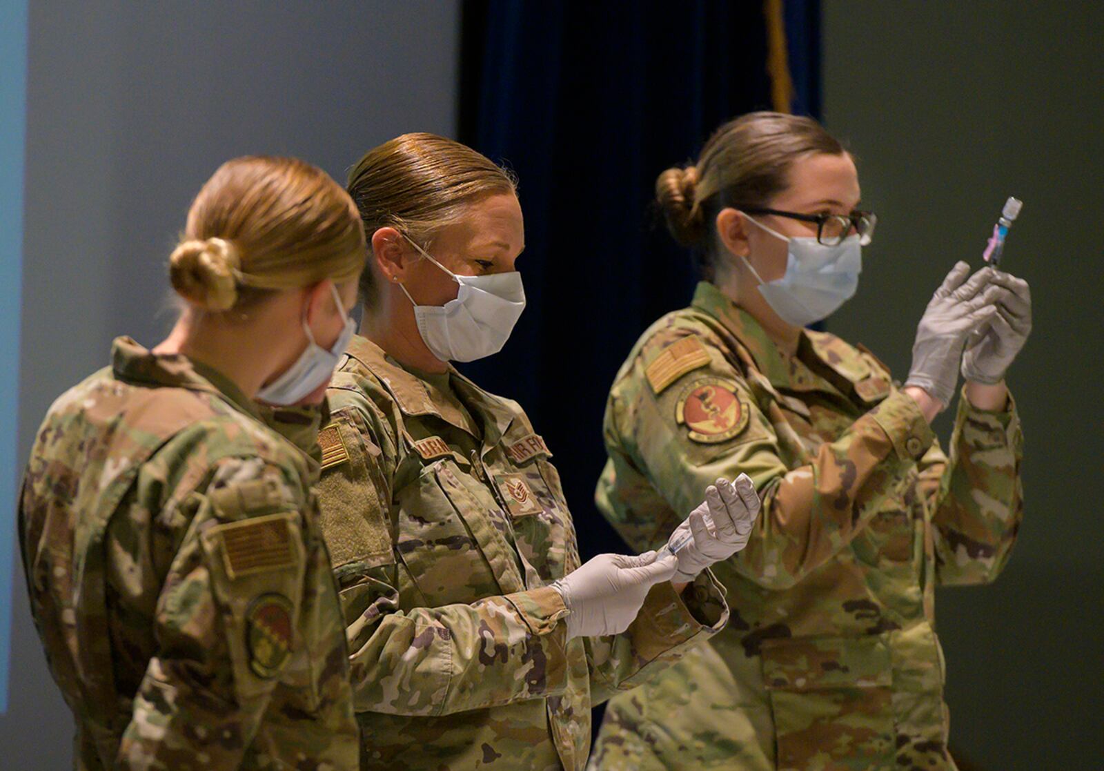 Staff Sgt. Allison Turner and Staff Sgt. Elizabeth Ciero, both with the 88th Healthcare Operations Squadron, fill syringes with the COVID-19 vaccine Jan. 8 in the Wright-Patterson Medical Center auditorium. The Airmen were preparing the syringes to vaccinate health care workers and other Phase 1 Airmen. U.S. AIR FORCE PHOTO/R.J. ORIEZ