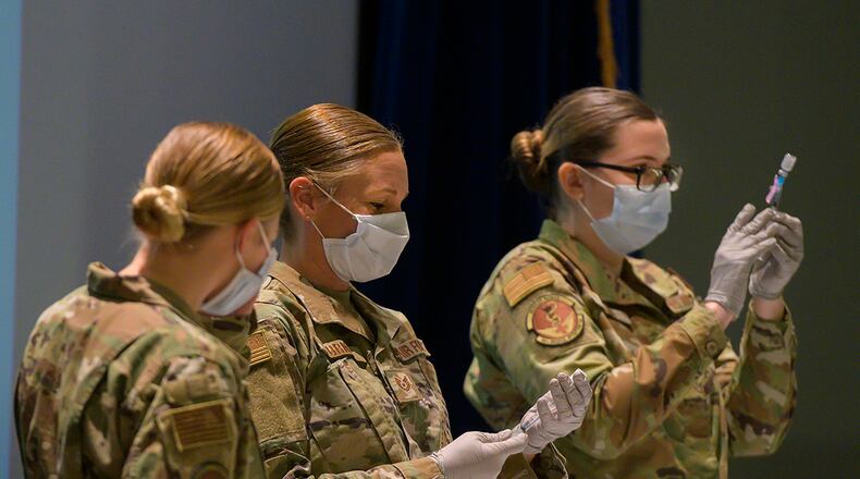 Staff Sgt. Allison Turner and Staff Sgt. Elizabeth Ciero, both with the 88th Healthcare Operations Squadron, fill syringes with the COVID-19 vaccine in the Wright-Patterson Medical Center auditorium. The Airmen were preparing the syringes to vaccinate health care workers and other Phase 1 Airmen. U.S. AIR FORCE PHOTO/R.J. ORIEZ