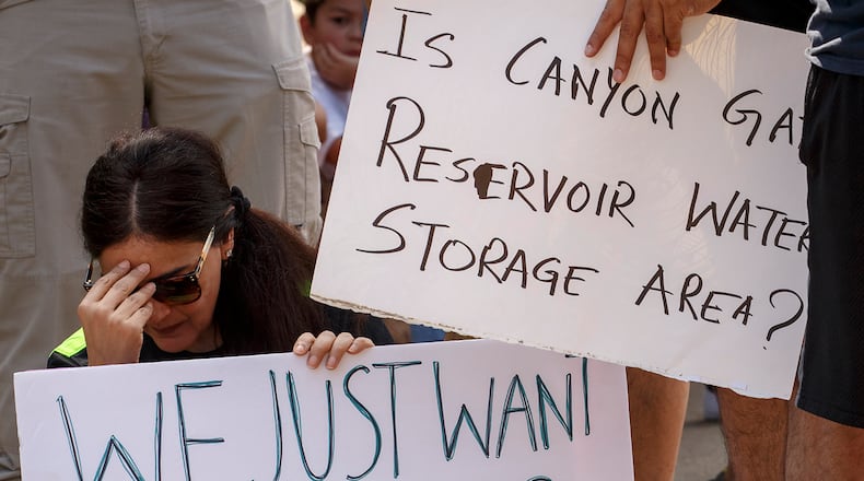 Cinco Ranch Canyon Gate subdivision resident Pia Anand holds her head as she joins demonstrators who gathered at a police road cbock outside their neighborhood on Saturday, Sept. 2, 2017, in Katy, Texas. The area remains cordoned off due to flood waters left by Hurricane Harvey. (Smiley N. Pool/Dallas Morning News/TNS) NO MAGAZINE SALES MANDATORY CREDIT; NO SALES; INTERNET USE BY TNS CONTRIBUTORS ONLY
