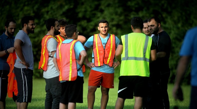 Mukhammad Shadhnanov (center, facing camera) said a donation of soccer equipment from Dayton Children’s Hospital will bring his Old North Dayton neighborhood closer together. (Jim Noelker/Staff)
