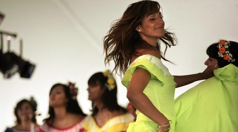 Colorfully dressed dancers perform on stage with the band Rondella at the Hispanic Heritage Festival on Patterson and First streets. FILE